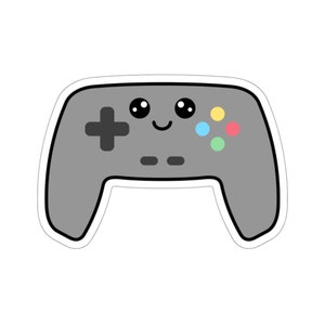May include: A gray video game controller with a happy face and colorful buttons.