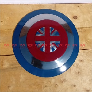 May include: A round, blue and silver shield with a red center featuring a Union Jack flag design.