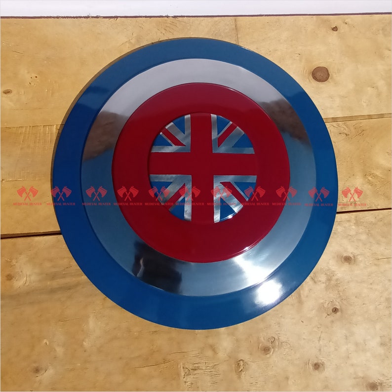 May include: A round, blue and silver shield with a red center featuring a Union Jack flag design.
