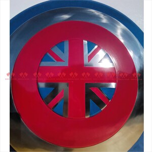 May include: A red, white, and blue Union Jack flag is displayed on a silver and blue circular shield. The shield has a raised rim.
