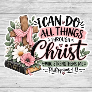 May include: A sticker featuring a wooden cross draped in pink fabric, a black Holy Bible, and white and pink flowers. The text reads: I CAN DO ALL THINGS THROUGH Christ WHO STRENGTHENS ME Philippians 4:13, accented with small pink hearts.