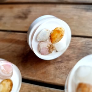 May include: White resin ring with a variety of seashells embedded in the resin. The shells are white, pink, and brown.