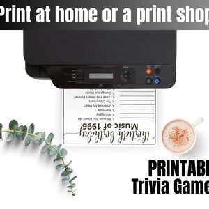 May include: A black printer outputting a white sheet of paper with the text Music of 1996 and Thirtieth Birthday, featuring a list of song titles. Beside the paper is a white mug filled with a light brown beverage and a green eucalyptus branch.