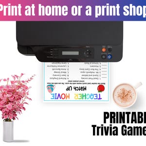May include: A black printer outputting a Teacher Movie Match Up trivia game sheet with a list of films and actors. Beside it sits a white mug filled with a frothy brown beverage and a white vase containing a vibrant pink leafy plant.