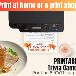 May include: A black printer outputting a white sheet of paper with Thanksgiving trivia text and graphics. Beside it sits a plate of sliced turkey with gravy and a cup of coffee. The text reads Print at home or a print shop and Printable Trivia Games.
