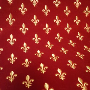 May include: Red fabric with a repeating pattern of gold fleurs-de-lis.