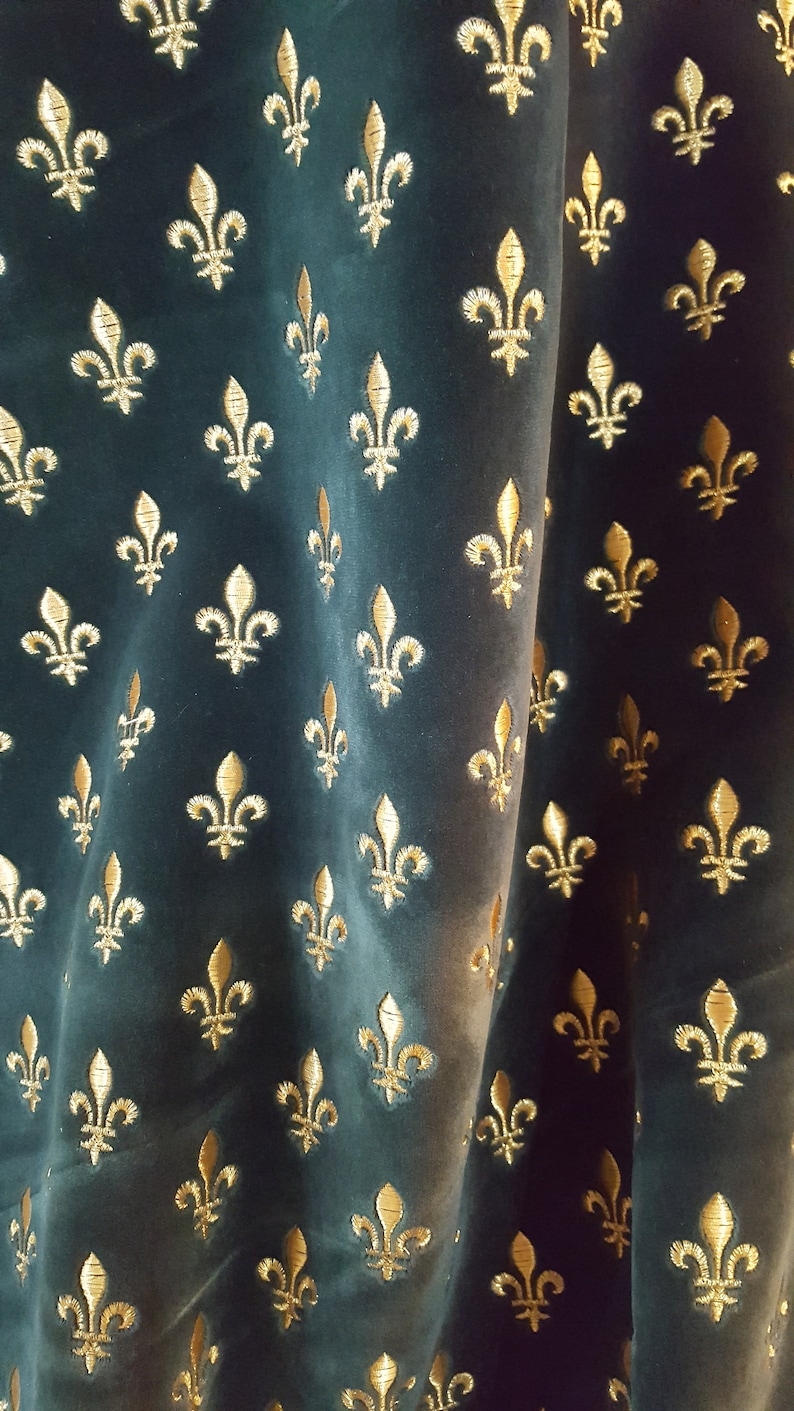 May include: A dark green fabric with a repeating pattern of gold fleurs-de-lis.