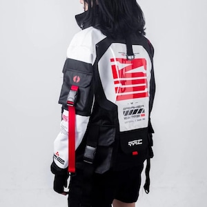 May include: A black and white jacket with red accents and multiple pockets. The jacket has a large white panel on the back with red and black text that reads "SPEAKER MULTI TYPE R UNIFIED + DESIGN INC".