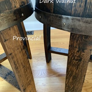 May include: Two wooden barrel stools, one stained dark walnut and the other provincial. Both stools have metal bands and rivets around the top.
