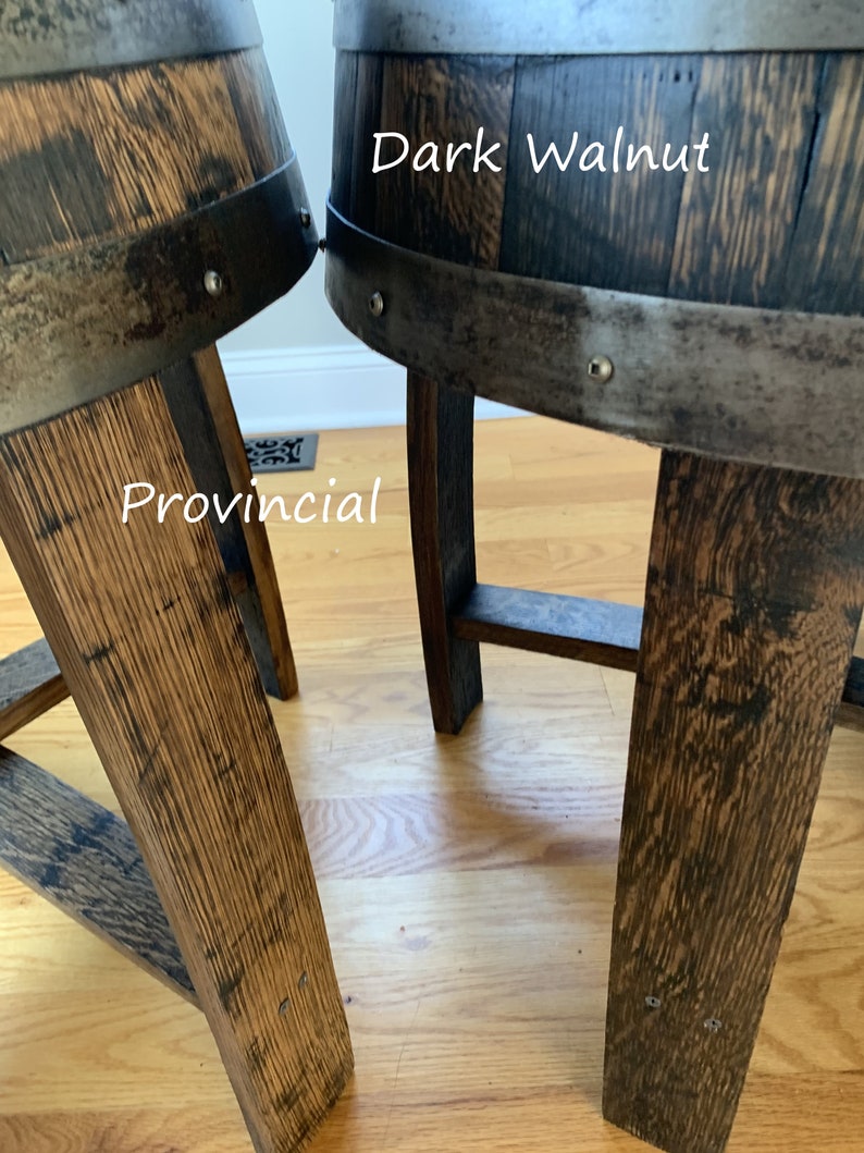 May include: Two wooden barrel stools, one stained dark walnut and the other provincial. Both stools have metal bands and rivets around the top.