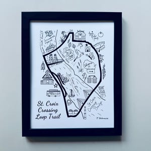 May include: Black framed art print featuring a hand-drawn map of the St. Croix Crossing Loop Trail. The map includes landmarks, a river, and the text "St. Croix Crossing Loop Trail". The artwork is in black and white.