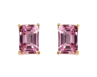 May include: A pair of stud earrings featuring rectangular, light pink gemstones set in gold. The gemstones have a faceted cut, reflecting light. The earrings are displayed against a white background.