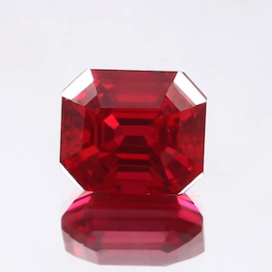 Peut inclure: Une pierre précieuse de couleur rouge foncé taillée en émeraude avec un haut poli.