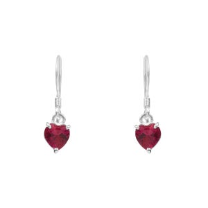 Puede incluir: Un par de pendientes colgantes plateados, cada uno con una piedra preciosa roja oscura en forma de corazón. Las piedras están sujetas por cuatro garras, y los pendientes tienen un diseño de gancho simple.