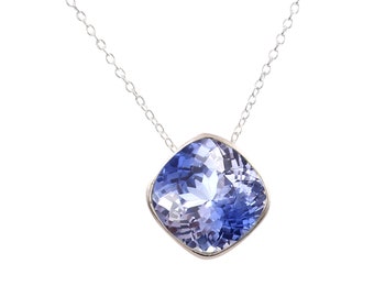 May include: A silver chain necklace with a large, cushion-cut blue gemstone pendant.