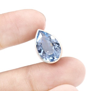 Puede incluir: Un colgante de piedra preciosa azul en forma de l&aacute;grima con un engaste de plata.