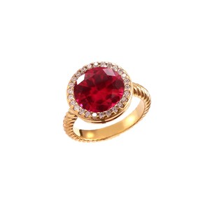 Op de afbeelding: Een gouden ring met een grote, ronde, gefacetteerde dieprode edelsteen in het midden. De centrale steen is omringd door een halo van kleine, heldere, fonkelende steentjes. De ringband heeft een opvallende gedraaide, touwachtige textuur.