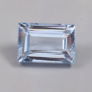 Könnte beinhalten: Ein hellblauer Aquamarin-Edelstein mit einem rechteckigen Smaragdschliff.