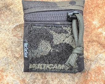 Mini Plus, In black multi cam black Velcro on the front, top zipped organizational pouch.