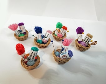 May include: Eight miniature wicker baskets filled with colorful yarn balls and knitting needles. Each basket has a label with the text "Knitting Worsted" and the brand name "MMM".