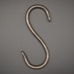 May include: A single, metallic S-hook, crafted from a sturdy, silver-toned metal. The hook is curved, with a smooth, slightly textured surface, and is designed for hanging items. The background is a solid, neutral gray.