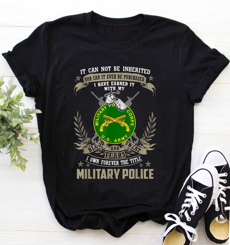Puede incluir: Camiseta negra con un emblema de polic&iacute;a militar verde y amarillo. El texto dice "No se puede heredar ni se puede comprar. Me lo he ganado con mi sangre y mis l&aacute;grimas. Soy due&ntilde;o para siempre del t&iacute;tulo de Polic&iacute;a Militar."