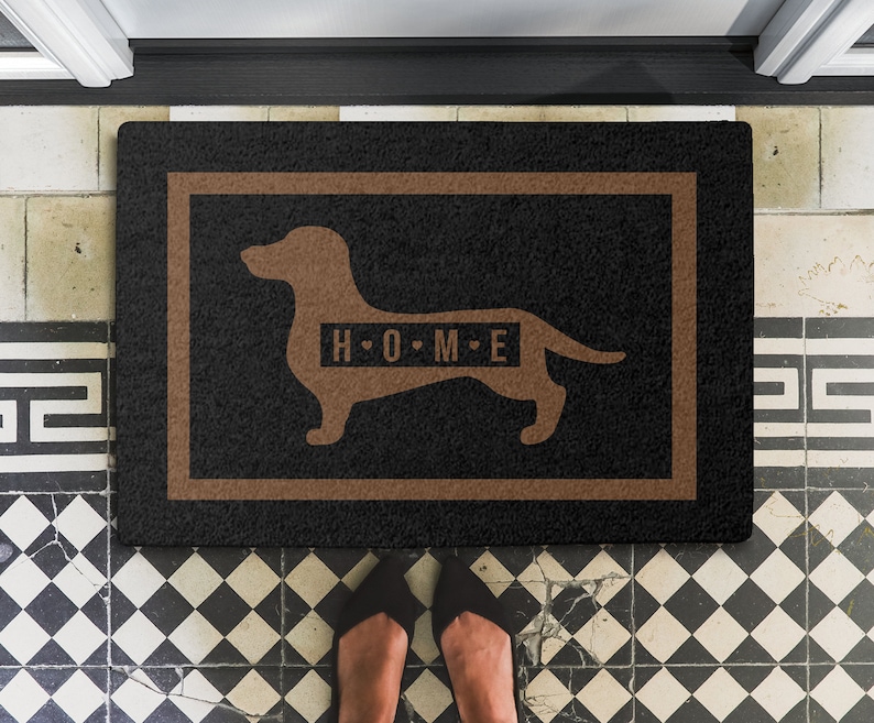 May include: Black doormat with a brown border and a brown dachshund silhouette with the text "H.O.M.E." inside the silhouette.