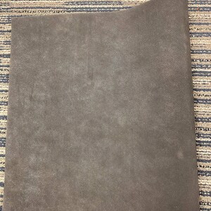 May include: A dark brown, rectangular yoga mat made of a textured material.