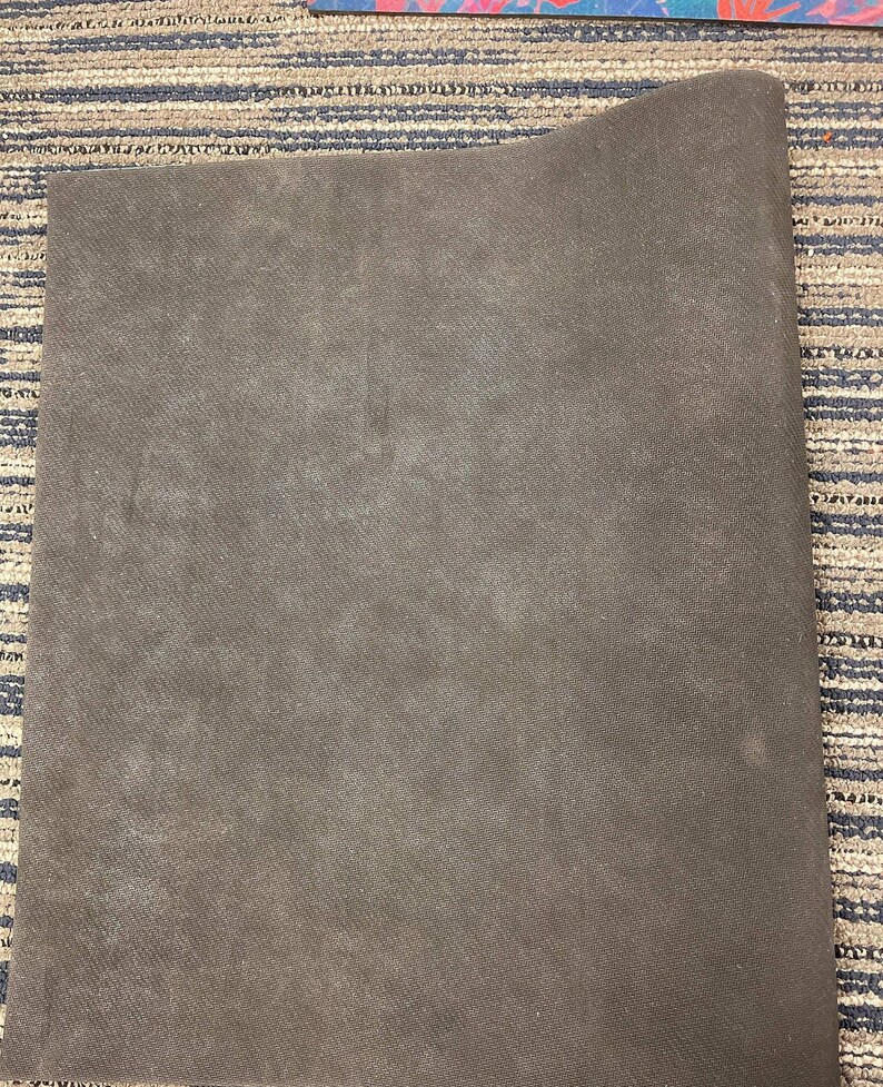 May include: A dark brown, rectangular yoga mat made of a textured material.