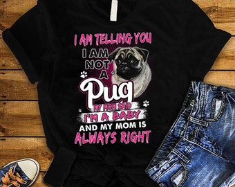Puede incluir: Camiseta negra con un gráfico de pug y el texto "I AM TELLING YOU I AM NOT A Pug MY MOM SAID I'M A BABY AND MY MOM IS ALWAYS RIGHT" en rosa y blanco. La camiseta se combina con pantalones cortos de mezclilla azules y zapatillas de lona.