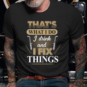 May include: Black t-shirt with a gold design that says "That's what I do I drink and I fix things". The design also includes two welding torches.