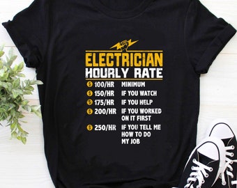 May include: Black t-shirt with the text "ELECTRICIAN HOURLY RATE" in yellow. The text lists hourly rates from £79 to £198 based on the level of involvement. A pair of black and white trainers is visible in the bottom right corner.