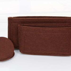 May include: A set of three brown felt bag organizers. The organizers are made of a thick, durable felt and have a variety of compartments and pockets to help keep your bag organized.