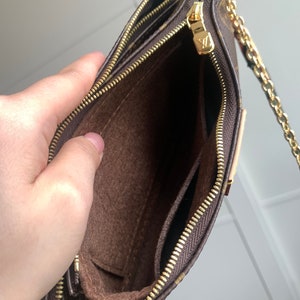 May include: A brown and gold chain strap purse with a brown fabric interior and two zippered compartments. The purse is open and the interior is visible.