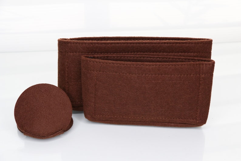 May include: A set of three brown felt bag organizers. The organizers are made of a thick, durable felt and have a variety of compartments and pockets to help keep your bag organized.