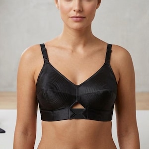 Może przedstawiać: Biały ceramiczny kubek z czarnym uchwytem i napisem "But First, Coffee" pogrubioną, czarną czcionką. Kubek jest ustawiony na rozmytym tle, sugerującym przytulne otoczenie.