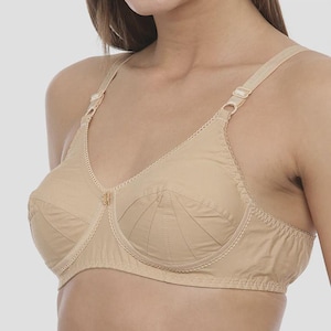 Könnte beinhalten: Ein beigefarbener BH mit verstellbaren Trägern und klassischem Design. Der BH hat genähte Cups für Halt und ein dekoratives Detail in der Mitte. Der Stoff scheint ein weiches, atmungsaktives Material zu sein.