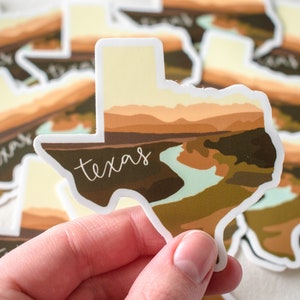 Puede incluir: Una colecci&oacute;n de pegatinas con la forma del estado de Texas. Cada pegatina presenta un dise&ntilde;o de paisaje en tonos marrones, beige y verdes, con la palabra "texas" en escritura blanca. Las pegatinas tienen un borde blanco.