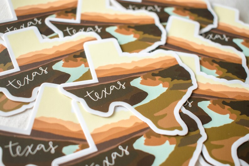 Puede incluir: Una colecci&oacute;n de pegatinas con forma de Texas. Cada pegatina presenta un dise&ntilde;o de paisaje en tonos marrones, beige y verdes, con la palabra "Texas" en una fuente manuscrita. Las pegatinas tienen un borde blanco.