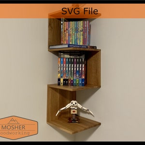 May include: A wooden corner shelf unit with three shelves, holding books and a small toy. The shelf is mounted on a white wall.