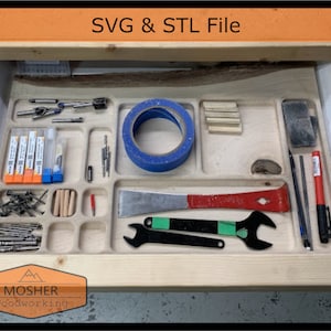 May include: A wooden drawer organiser with various tools and supplies, including a roll of blue painter's tape, a red and silver pry bar, a wrench, a sanding block, a set of drill bits, and a set of small tubes. The drawer is labelled "SVG & STL File".