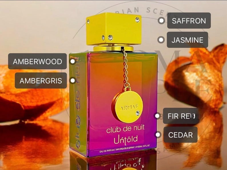 May include: A rectangular perfume bottle with a gradient of colors, from purple to orange, and a gold cap. The bottle has a gold charm with a chain. The scent notes include saffron, jasmine, fir red, and cedar.