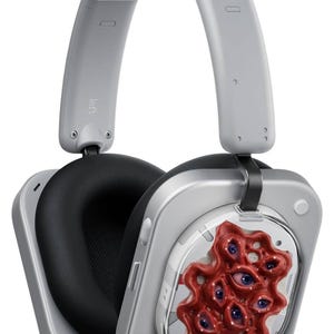 Puede incluir: Auriculares plateados de diadema con almohadillas negras. El auricular derecho presenta un dise&ntilde;o rojo de aspecto org&aacute;nico con m&uacute;ltiples ojos azules. La diadema es gris y el auricular izquierdo est&aacute; etiquetado como "Left".