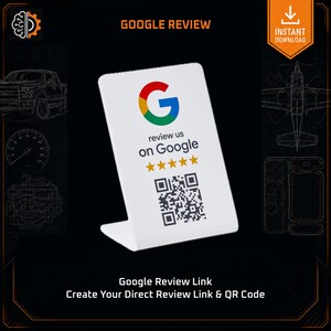 May include: A white L-shaped acrylic sign featuring the Google logo, the text "review us on Google", five yellow stars, and a black and white QR code. The sign is designed for business review collection and is presented on a dark background.