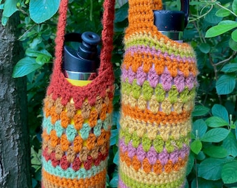 May include: Two crocheted water bottle holders with colorful stripes in shades of orange, green, brown, and pink. The holders have long straps for carrying.
