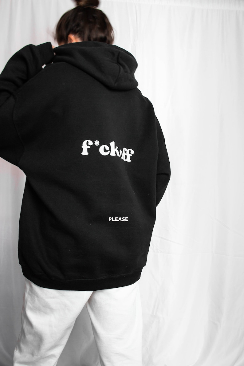 May include: Black hooded sweatshirt with the text "f*ck off" in white letters on the back. The text "PLEASE" is printed in white below the main text.