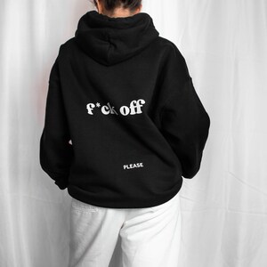 May include: Black hoodie with the text "f*ck off" in white letters on the back. The text "PLEASE" is printed in white below the main text.