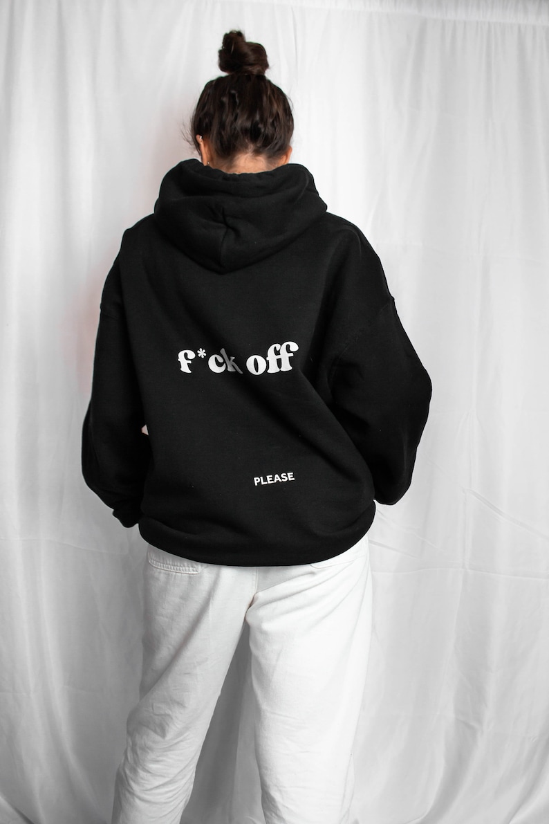 May include: Black hoodie with the text "f*ck off" in white letters on the back. The text "PLEASE" is printed in white below the main text.