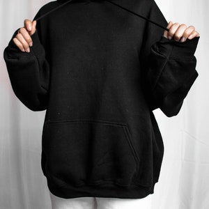 May include: A black oversized hoodie with a drawstring hood and a kangaroo pocket.