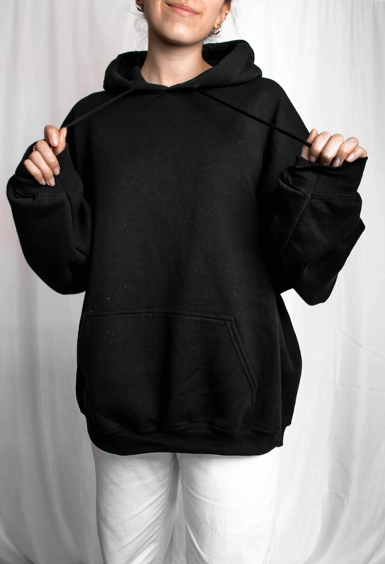 May include: A black oversized hoodie with a drawstring hood and a kangaroo pocket.